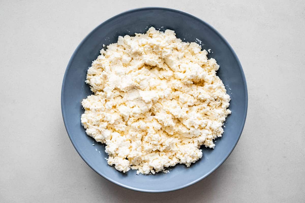 a bowl of crumbled feta cheese.