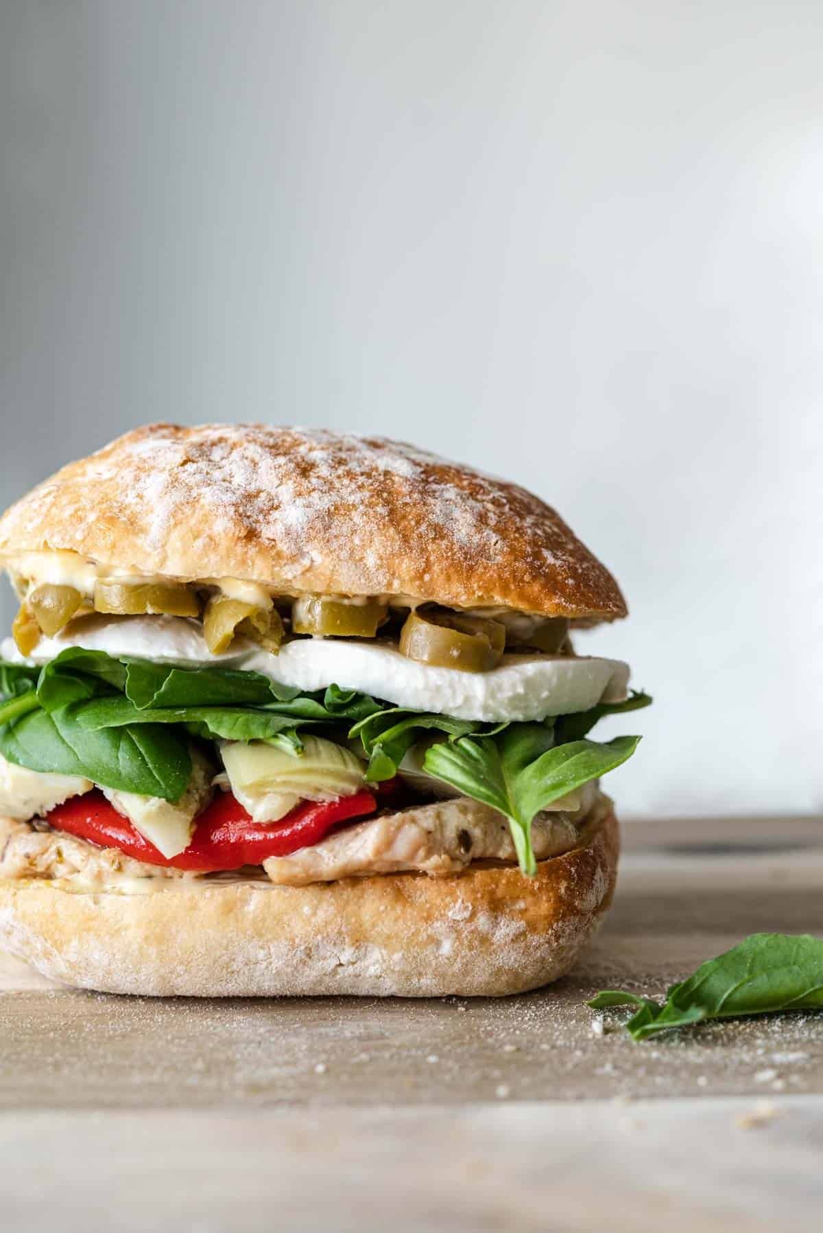 an antipasto chicken sandwich on a serving board.