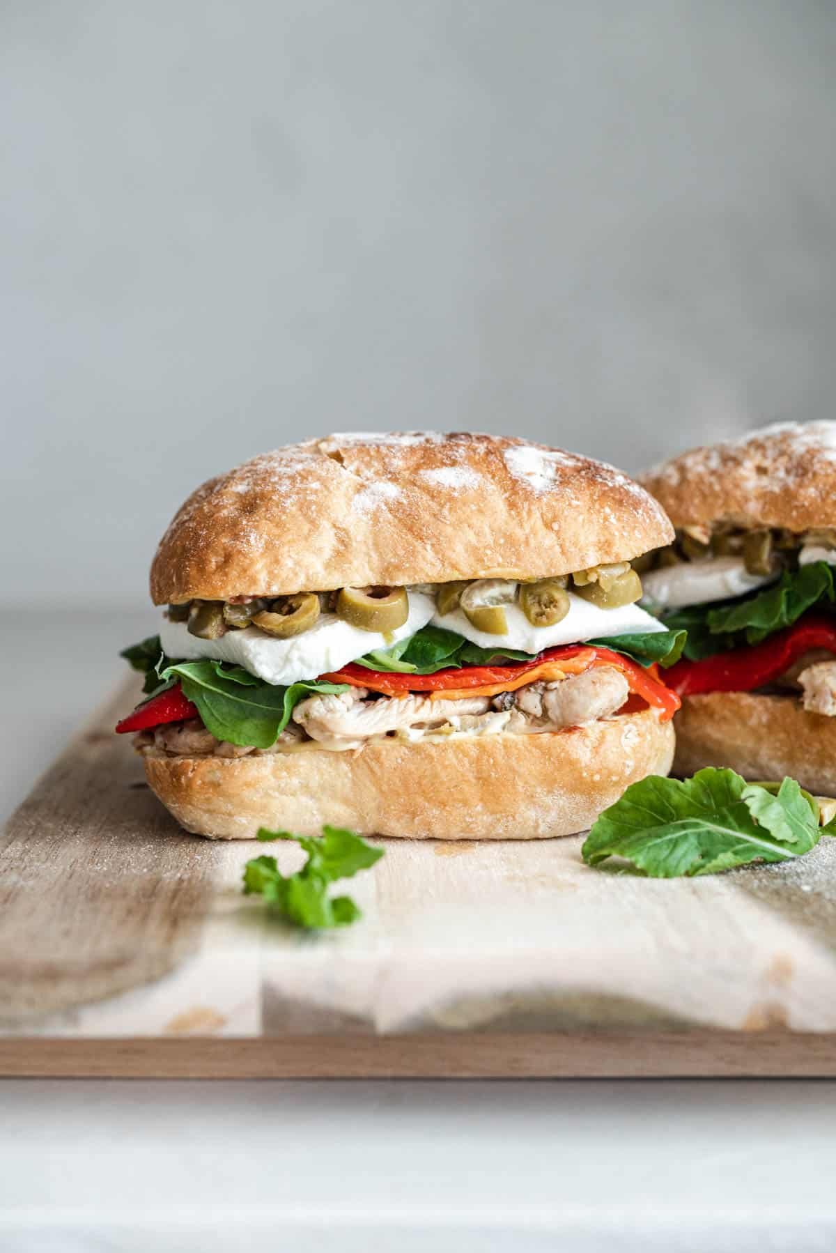 an antipasto chicken sandwich on a serving board.