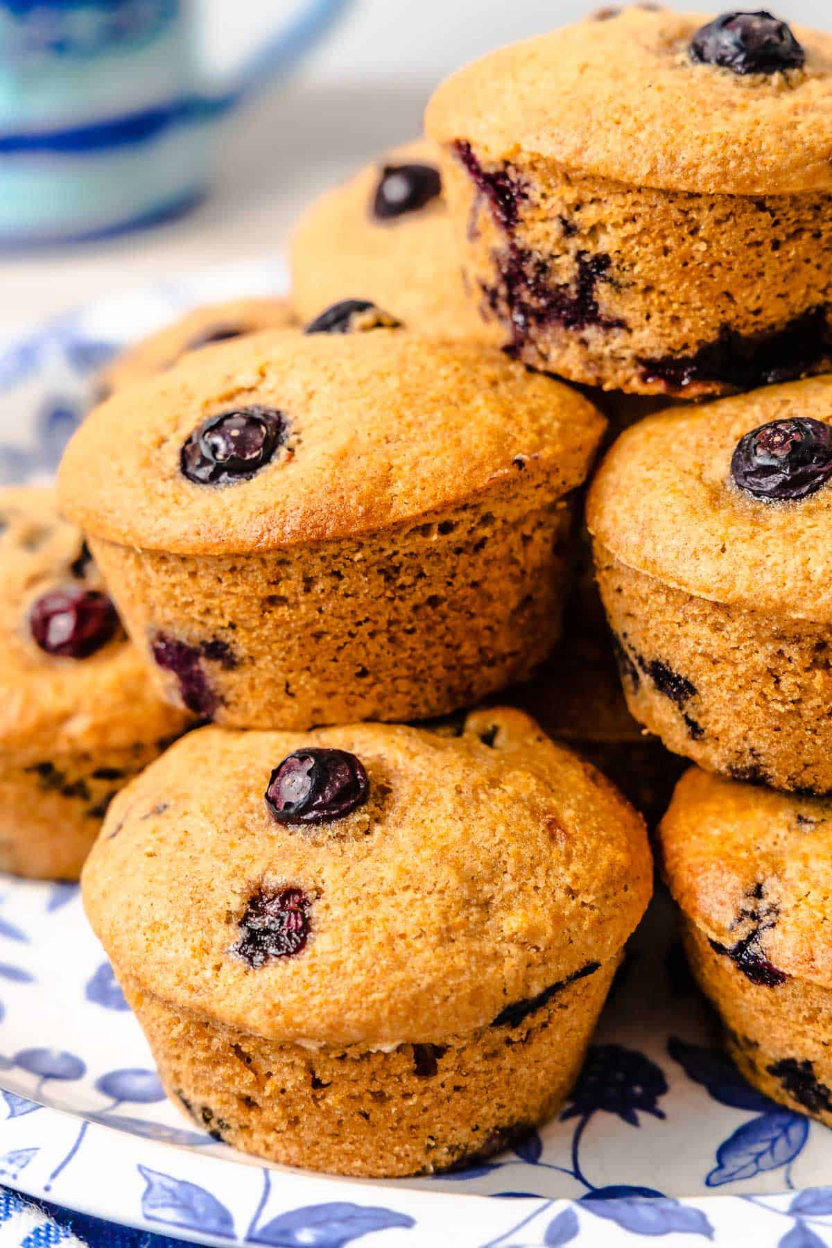 a several blueberry muffins stacked on a plate.