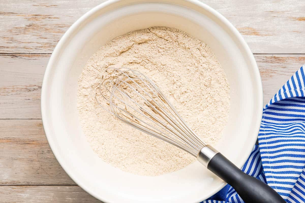 dry ingredients for blueberry muffins mixed together in a bowl with a whisk.