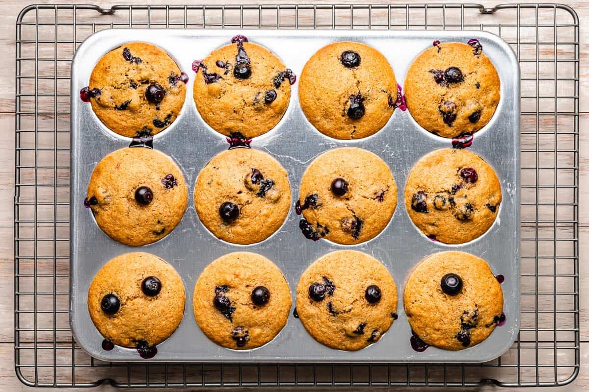 baked healthy blueberry muffins in a muffin tin.