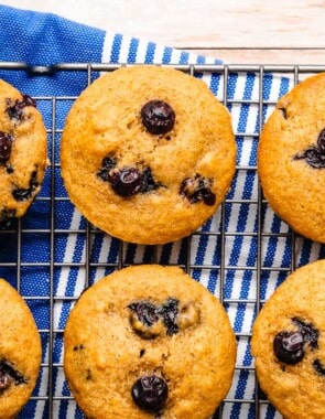 6 blueberry muffins on a cooling rack.