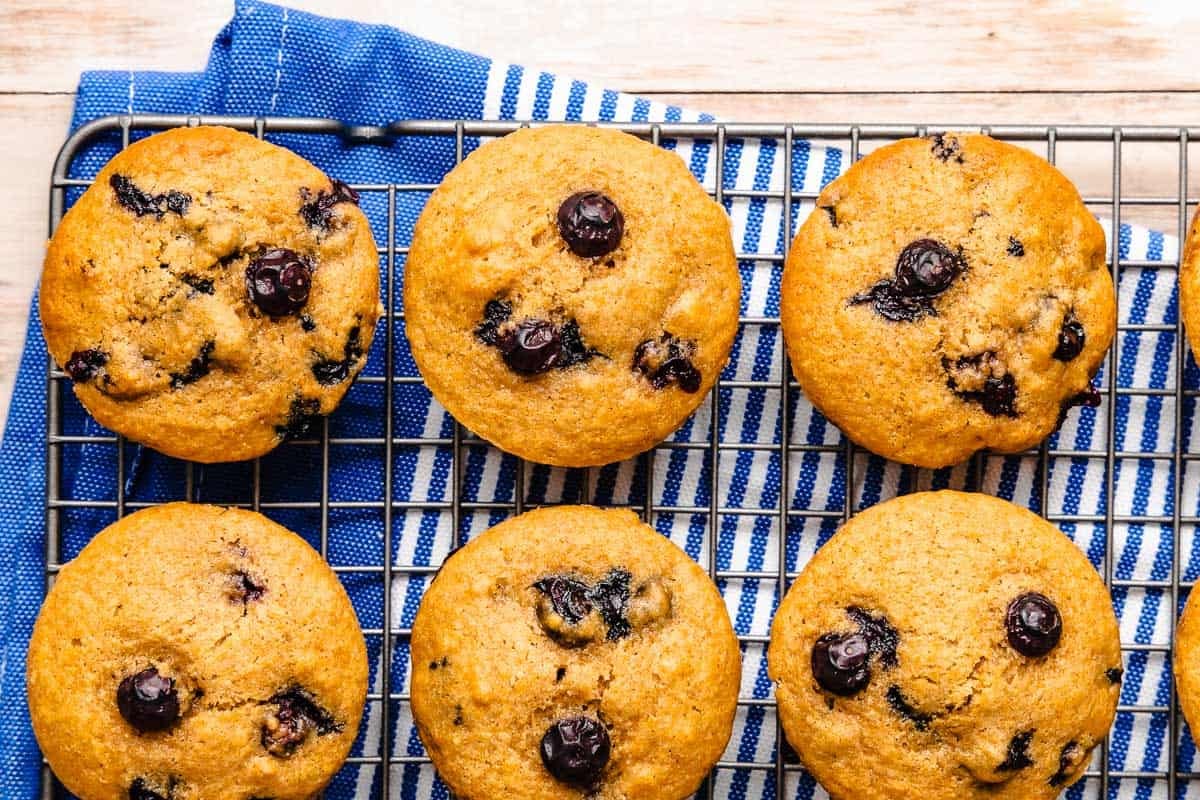 6 blueberry muffins on a cooling rack.