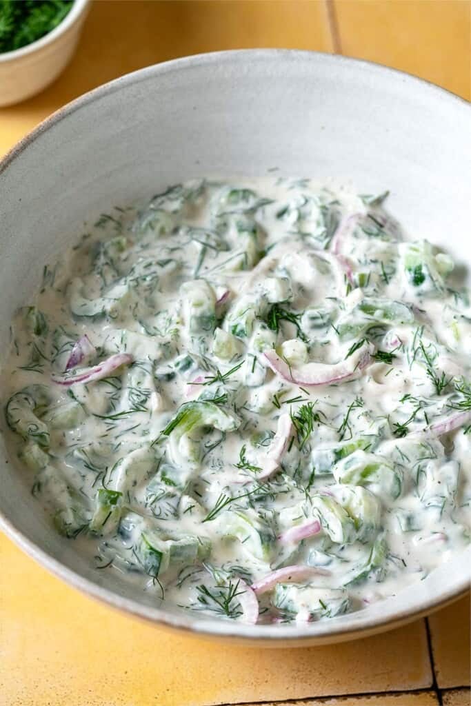 a creamy cucumber salad in a serving bowl.