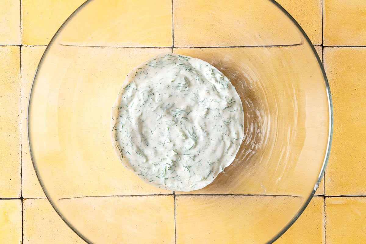 dressing for a creamy cucumber salad in a bowl.