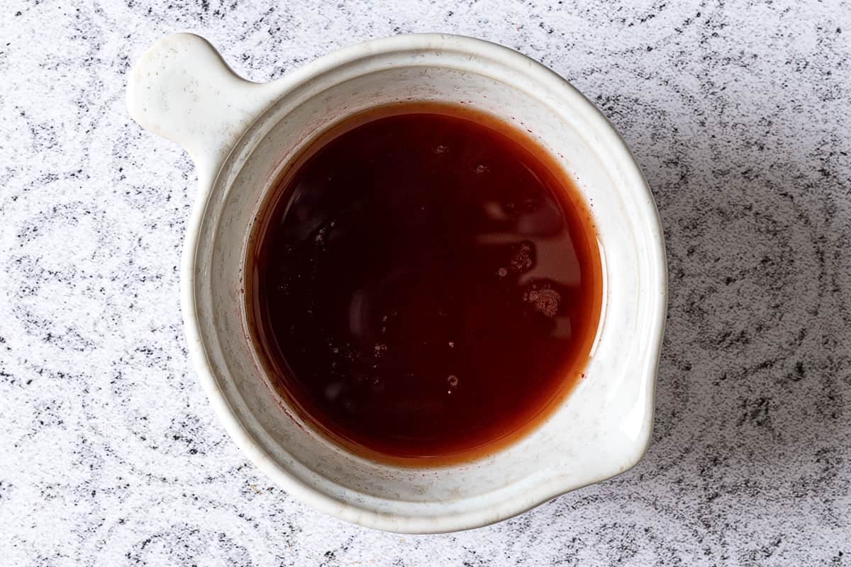 Pomegranate dressing with lemon, sumac and olive oil in a small pitcher.