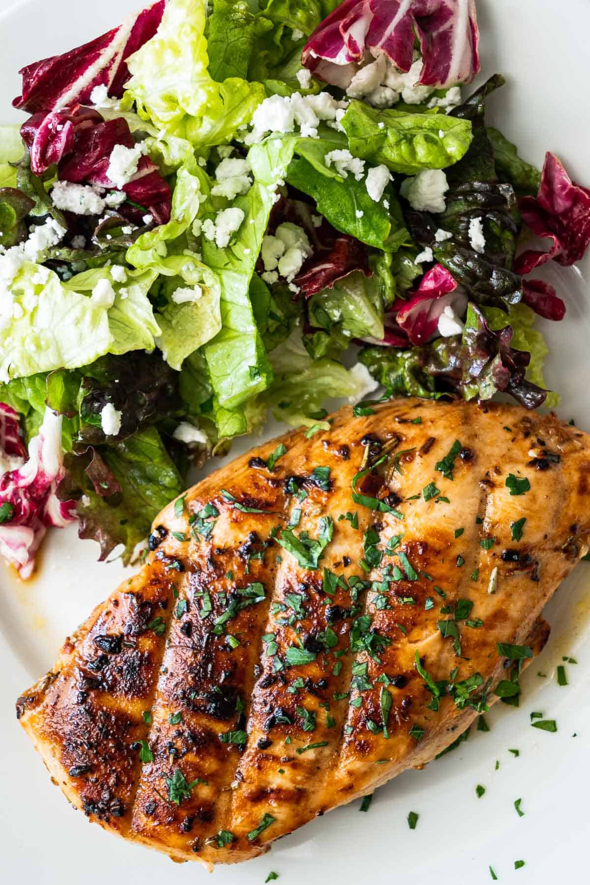 A grilled chicken breast with a side salad.