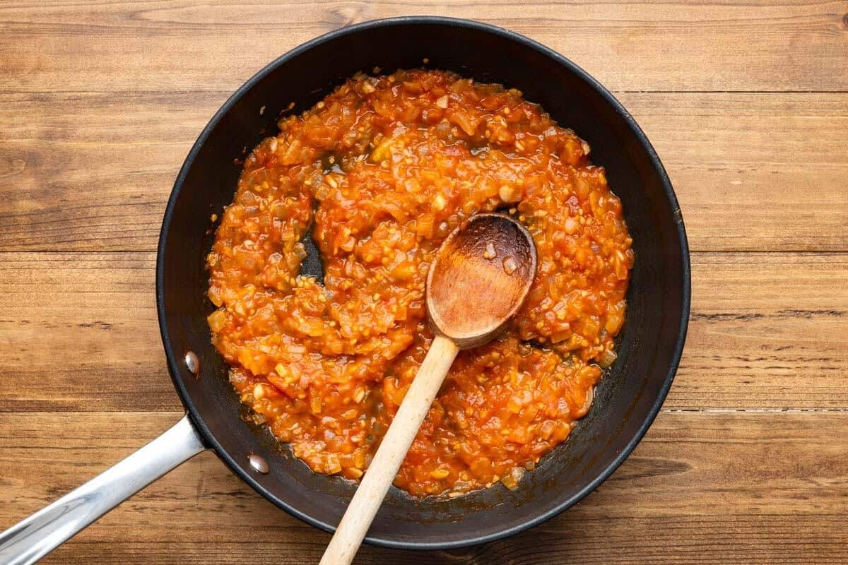garlic, onions and the reserved tomato flesh and juice in a skillet with a wooden spoon.
