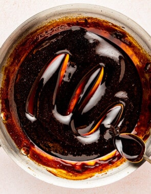 balsamic glaze being stirred with a spoon in a skillet.