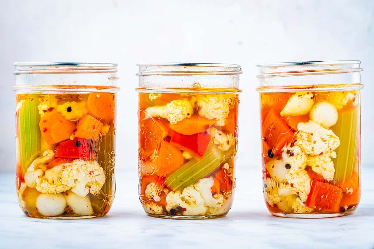 close up of three jars of giardiniera italian pickled vegetables.