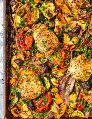 overhead photo of baked Greek sheet pan chicken with vegetables.