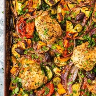 overhead photo of baked Greek sheet pan chicken with vegetables.