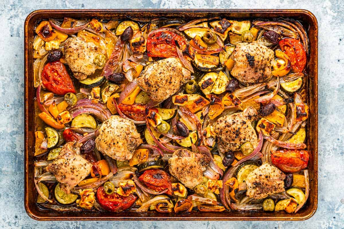 overhead photo of baked Greek sheet pan chicken and vegetables.