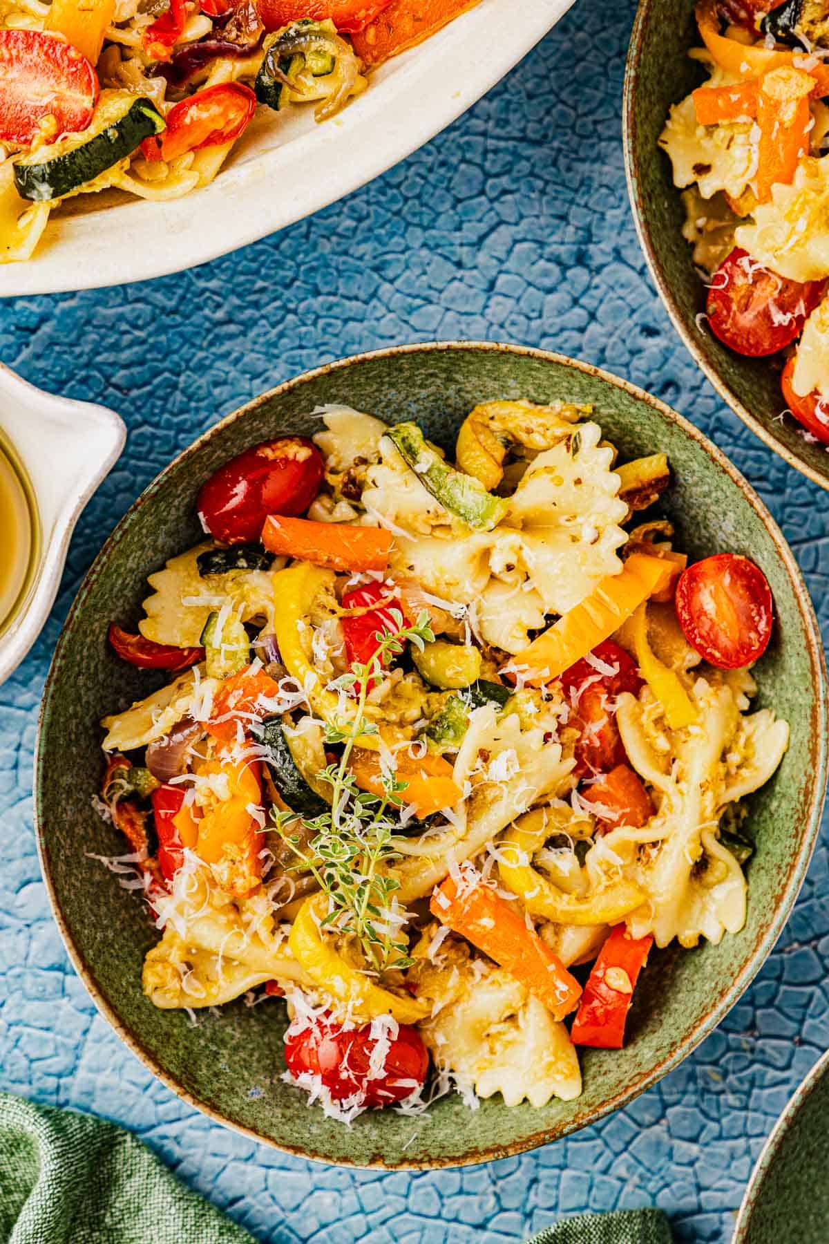 overhead photo of pasta primavera in a green bowl.