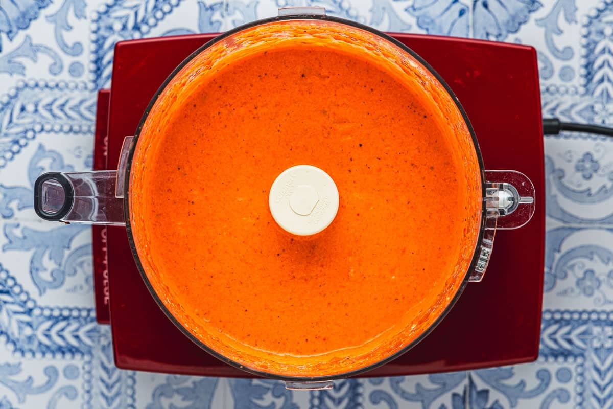 roasted red pepper sauce being mixed in a food processor.