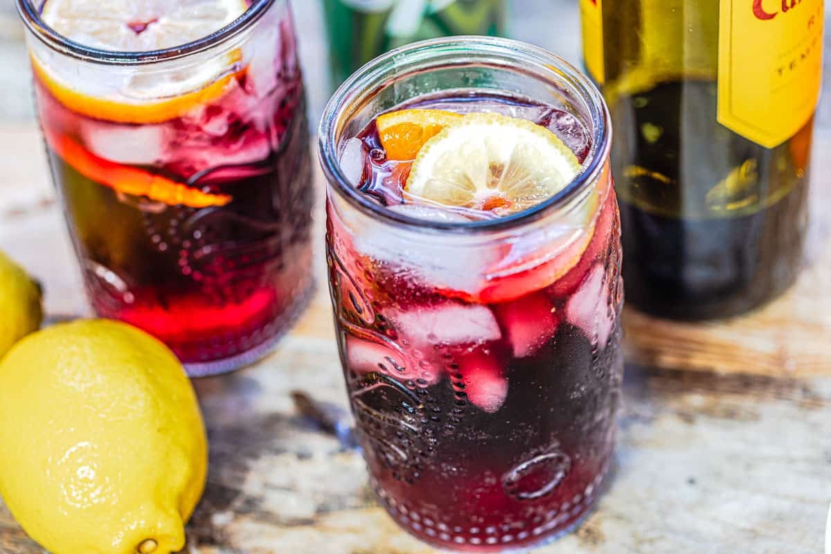 Two glasses of tinto de verano with a lemon and orange slice.