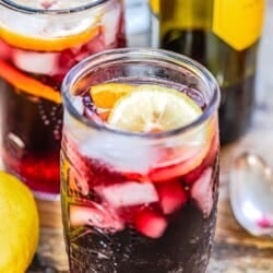 Two glasses of tinto de verano with a lemon and orange slice and lemon on the side.