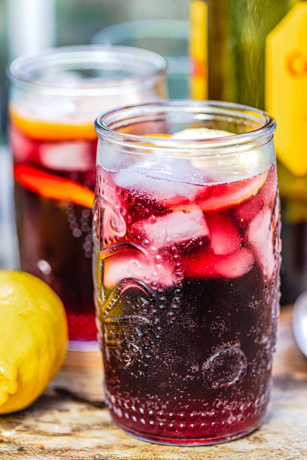 Glass of tinto de verano with a lemon and orange slice and ice.