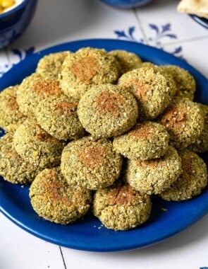 a stack of baked falafel on a blue plate.