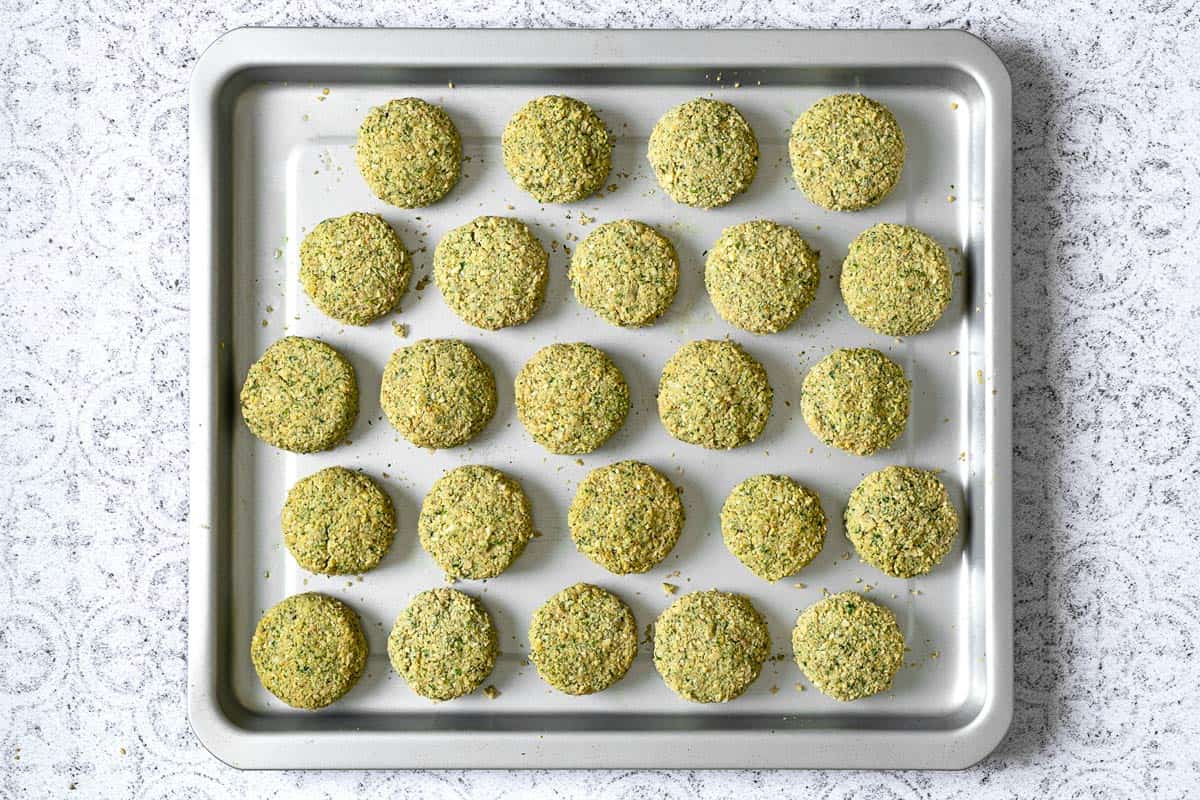 unbaked falafel laid out on a sheet pan.