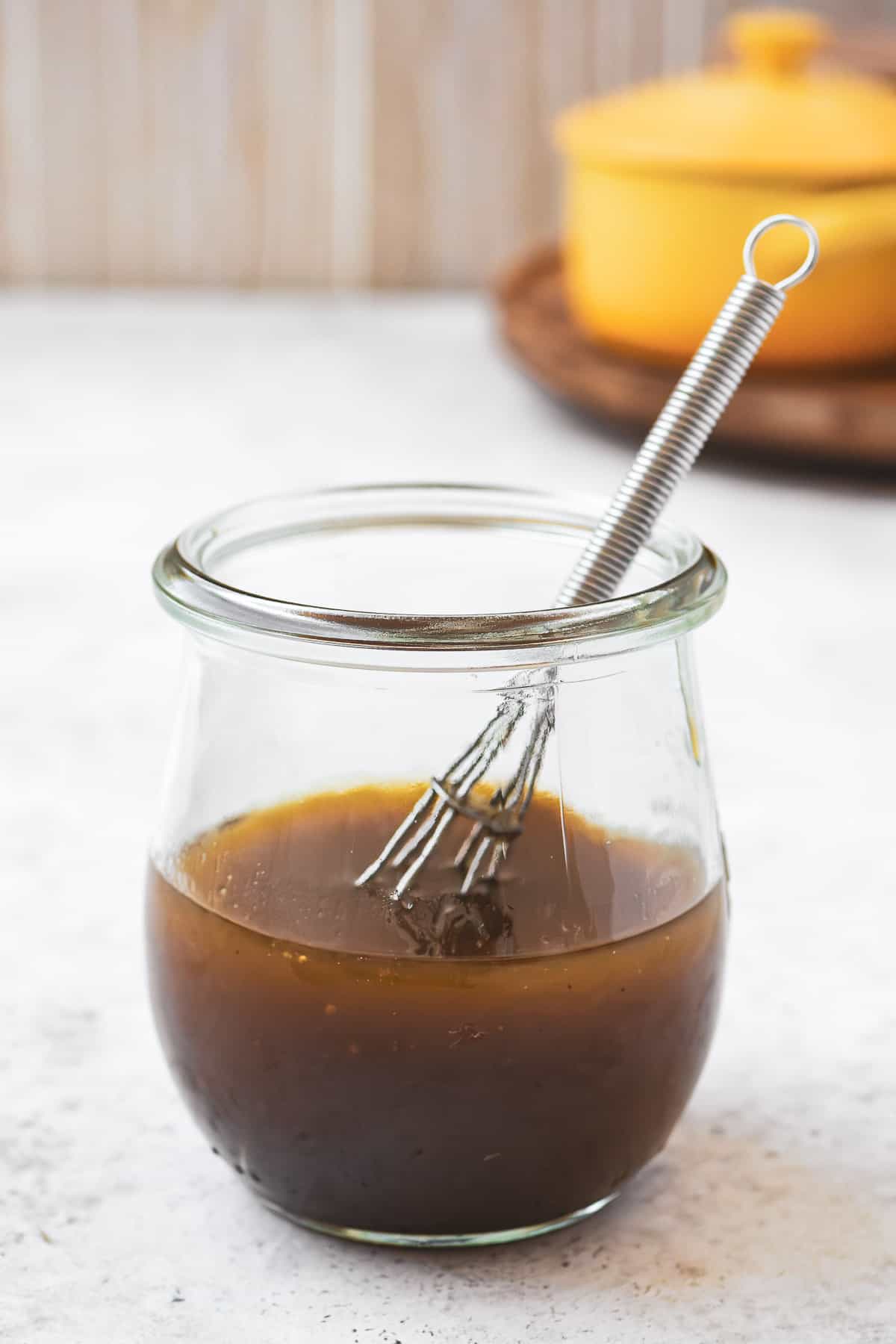 honey balsamic vinaigrette in a jar with a whisk.
