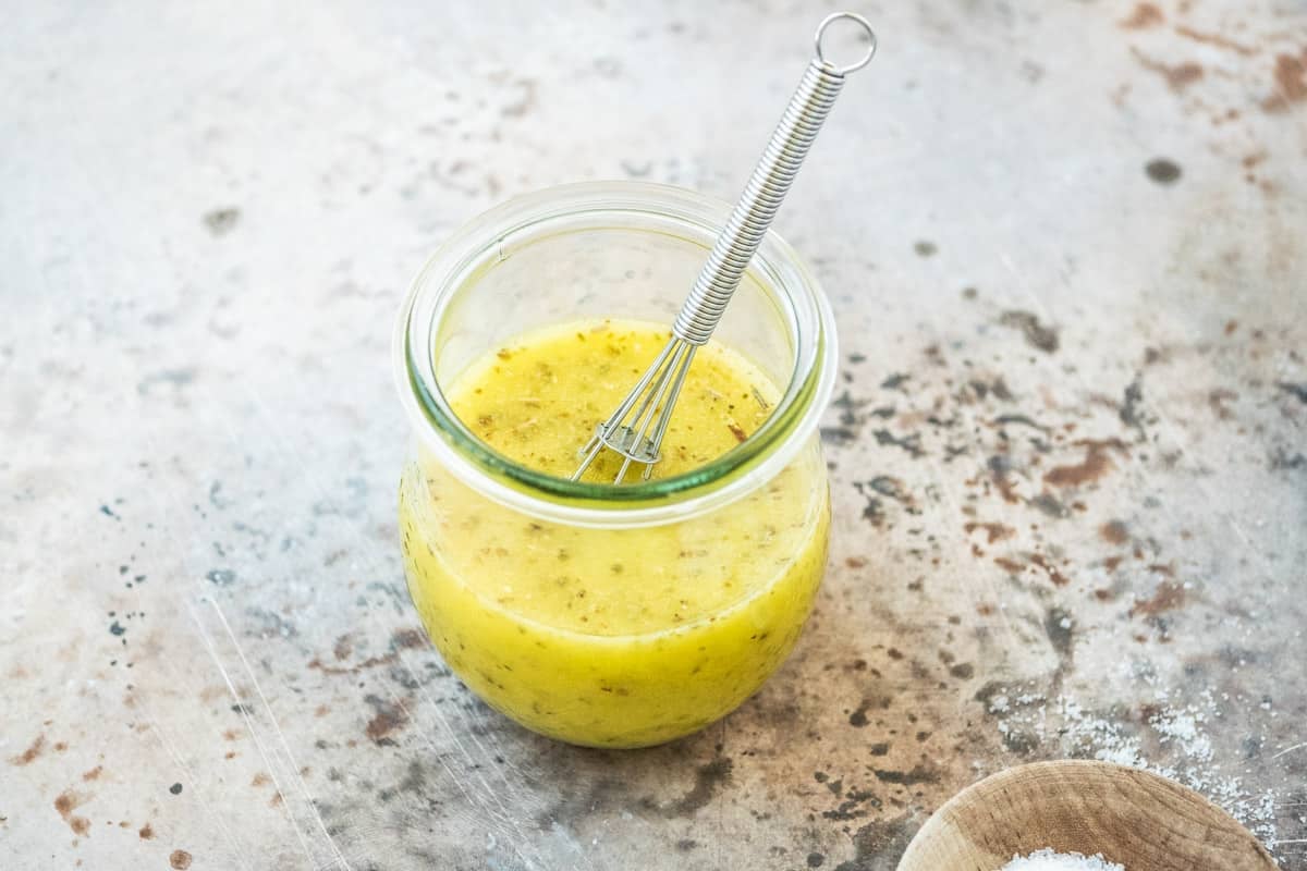 salad dressing for the maroulosalata in a glass jar with a whisk.