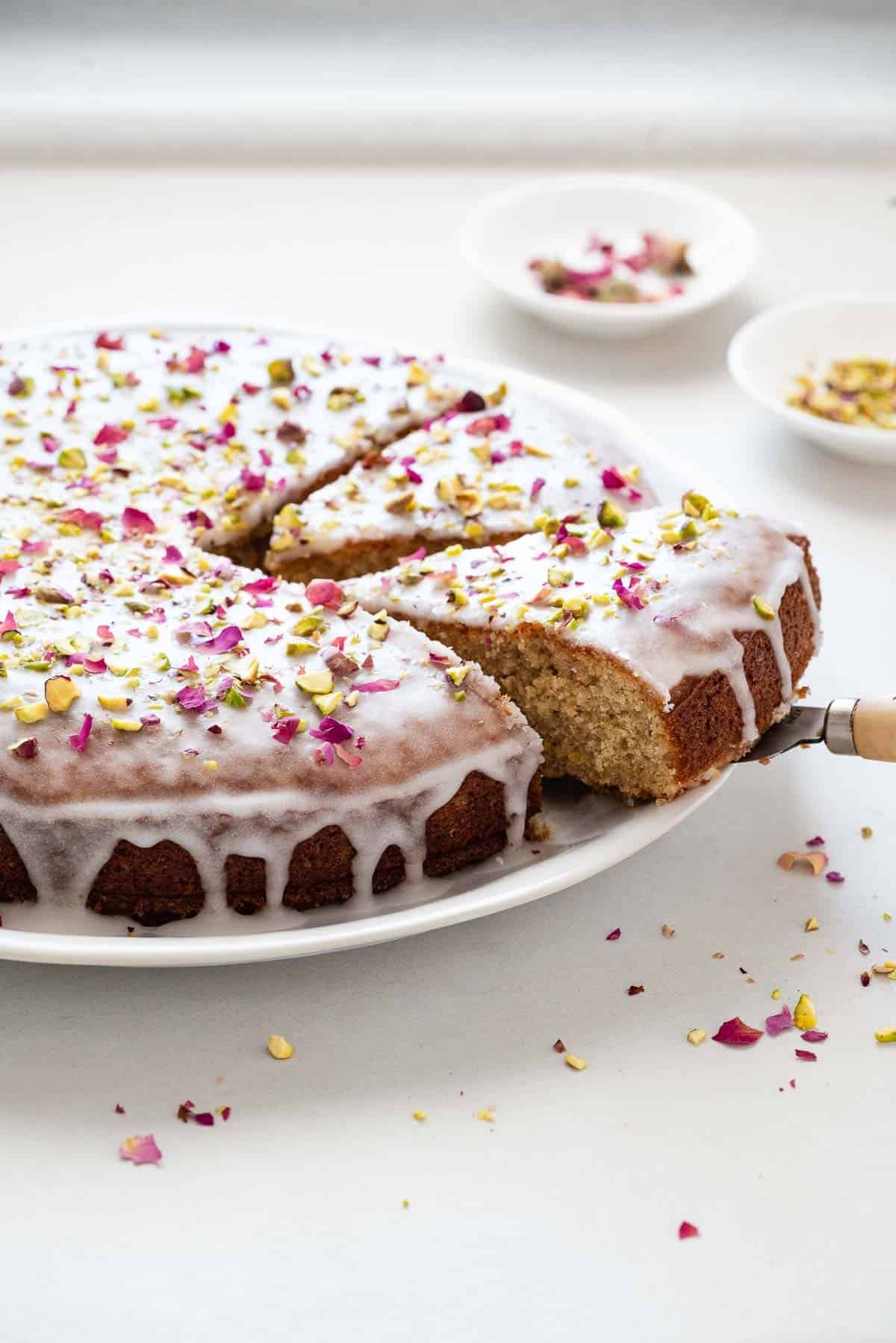 Slice of Persian love cake being lifted with a small wooden utensil.