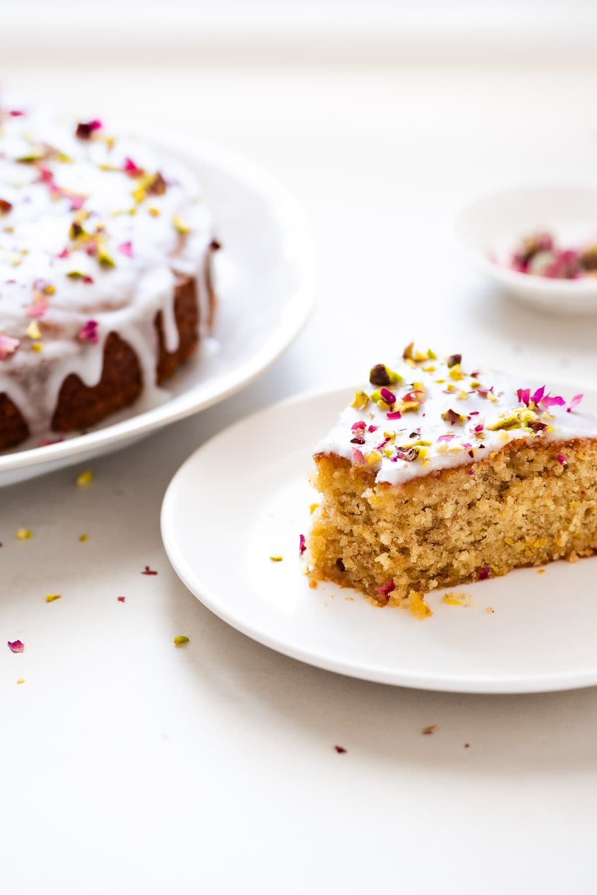 A slice of Persian love cake with a bite taken out, showing the crumb.