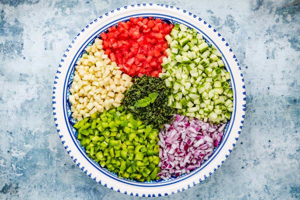 chopped vegetables for Slata Tounsiya Tunisian Salad separated in a serving bowl.