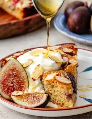 Honey being drizzled on a slice of fig cake.