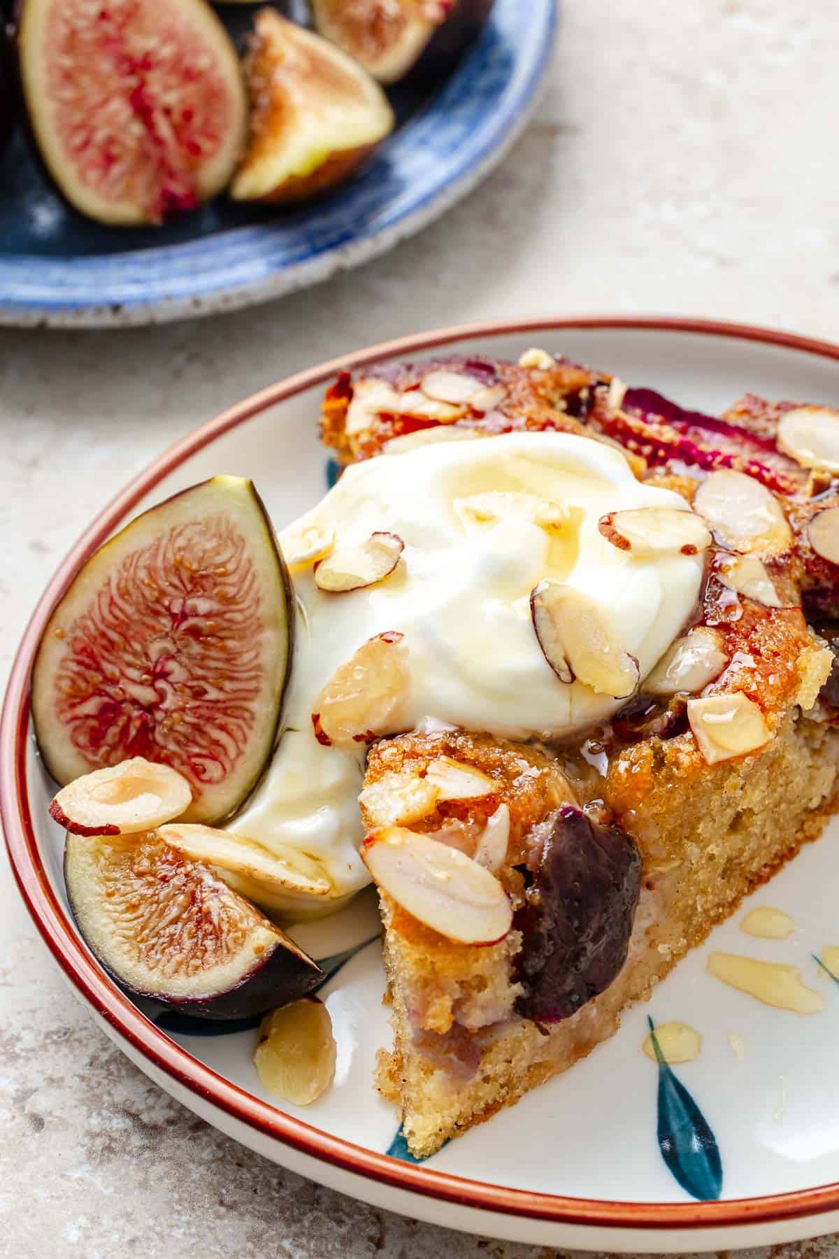 Slice of fig cake with Greek yogurt and a drizzle of honey on top.