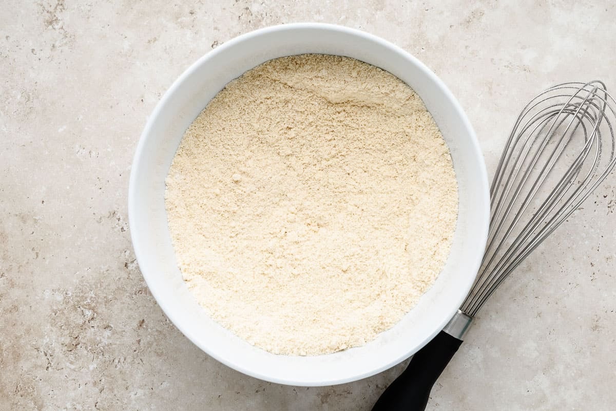 Almond flour, all-purpose flour, cinnamon, baking soda, and salt that has been whisked in a bowl.