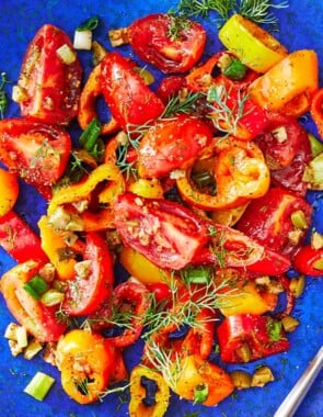 close up of a serving of bell pepper salad on a blue plate.
