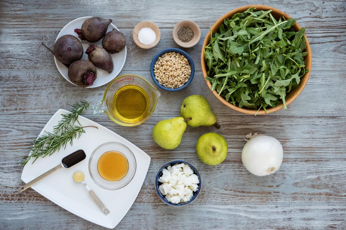 ingredients for beet and goat cheese salad including beets, pears, onion, rosemary, salt, pepper, pine nuts, arugula, crumbled chevre cheese, dijon mustard, olive oil, balsamic vinegar, and honey.