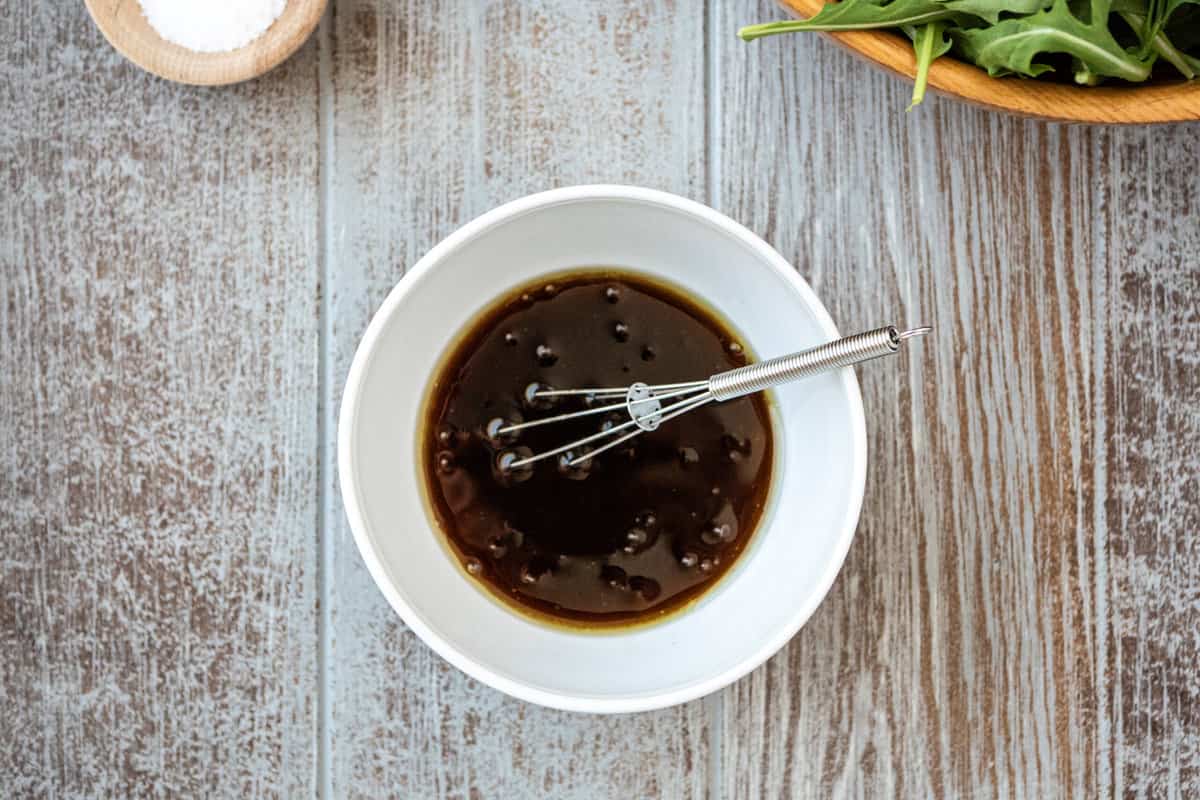 honey balsamic vinaigrette in a bowl with a whisk.