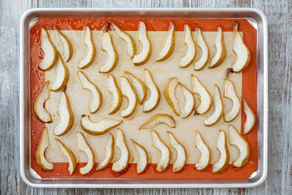 roasted pear wedges on a lined baking sheet.