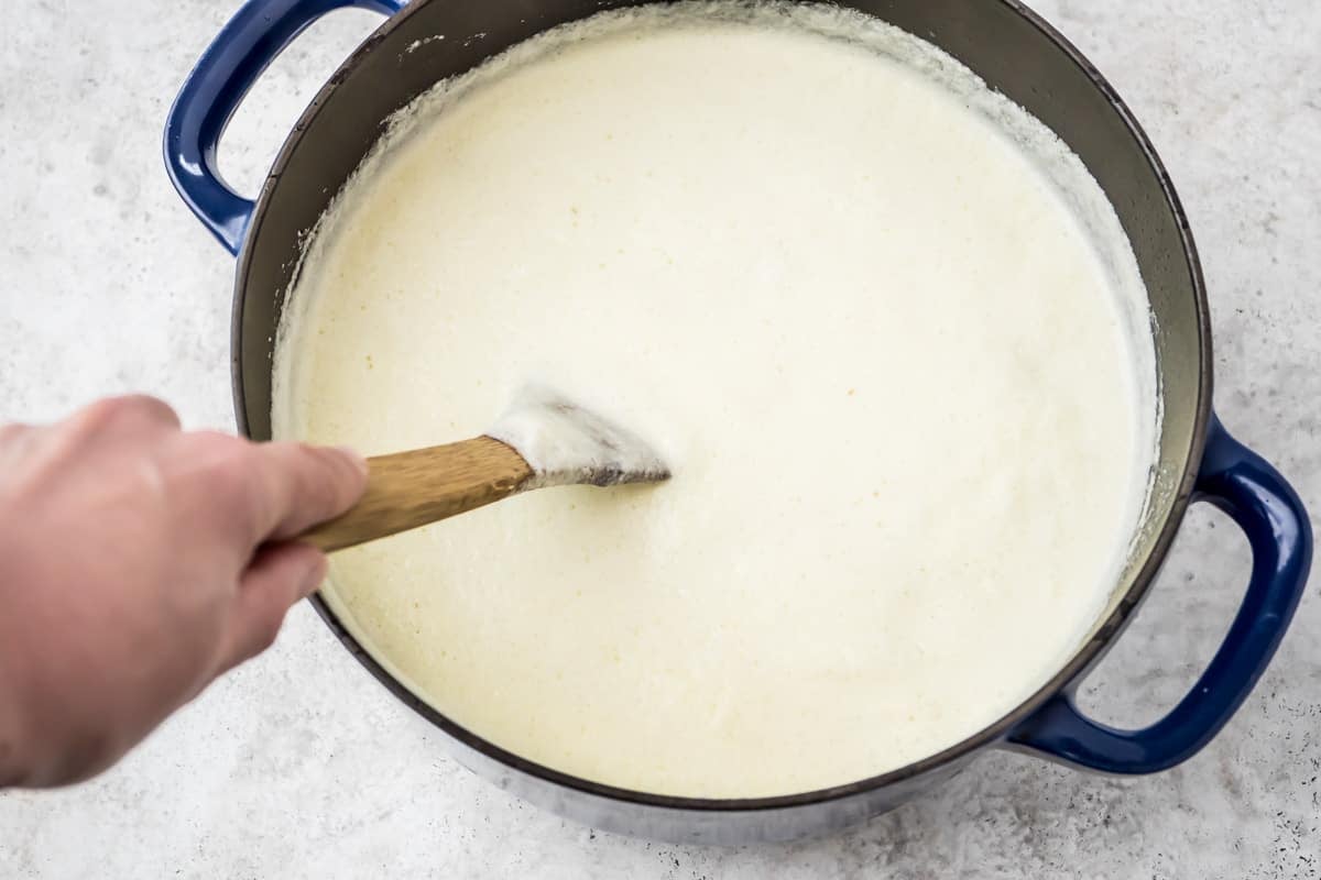 The avgolemono for the Youvarlakia Greek Meatball Soup being stirred in a pot as it cooks.