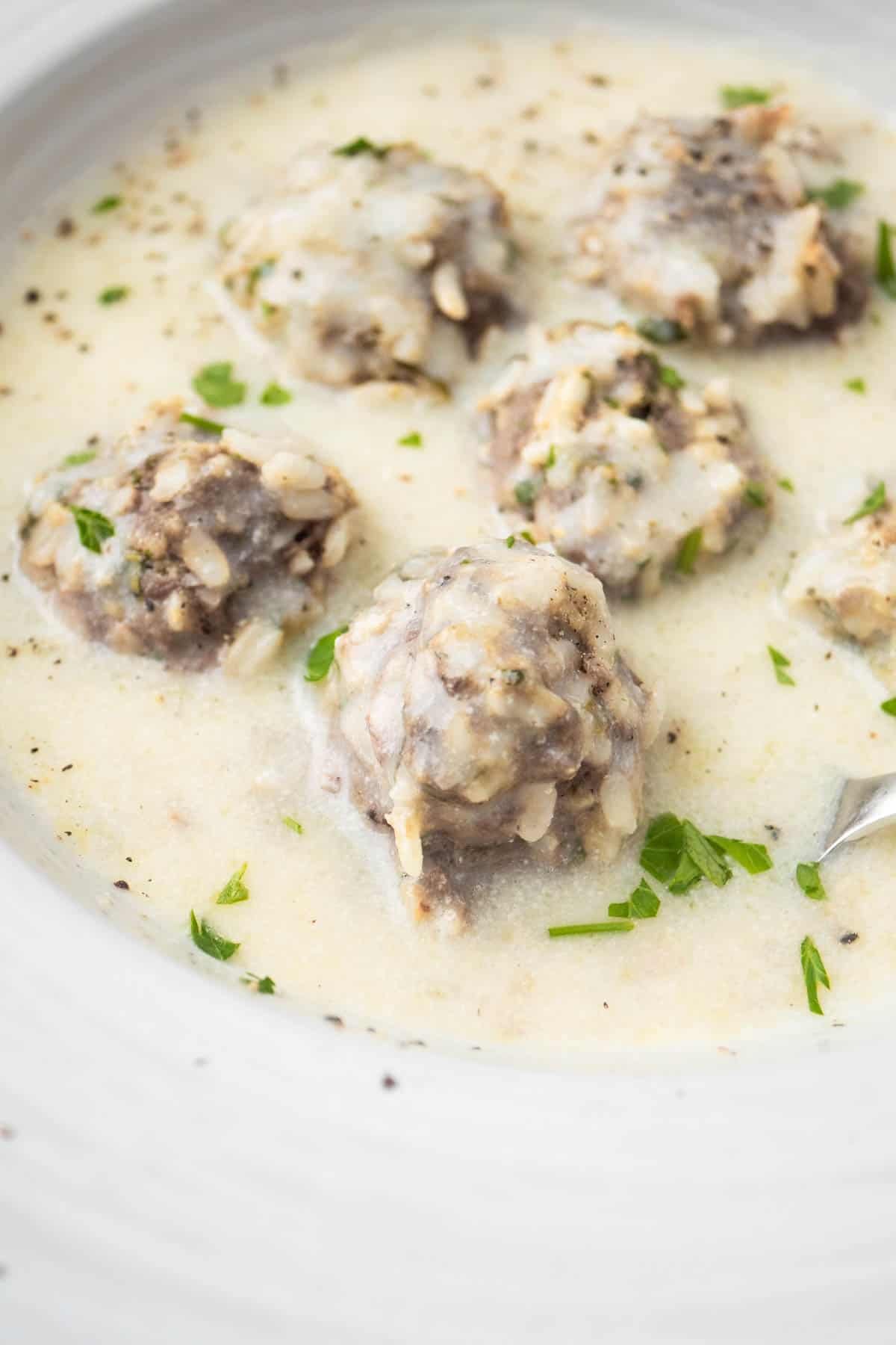 close up of Youvarlakia Greek Meatball Soup in a bowl.