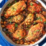 cooked Braised Chicken and Eggplant in a skillet on a wooden serving tray.