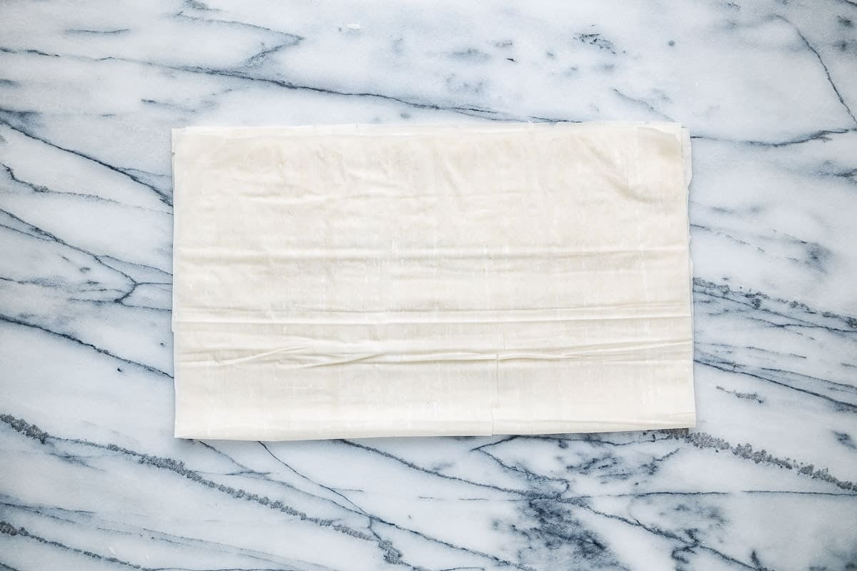 sheets of filo dough laid out on a countertop.