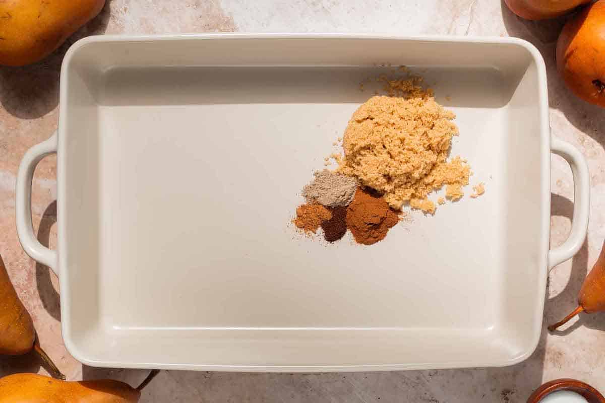 brown sugar, cinnamon, cardamom, cloves, and nutmeg in a baking dish.