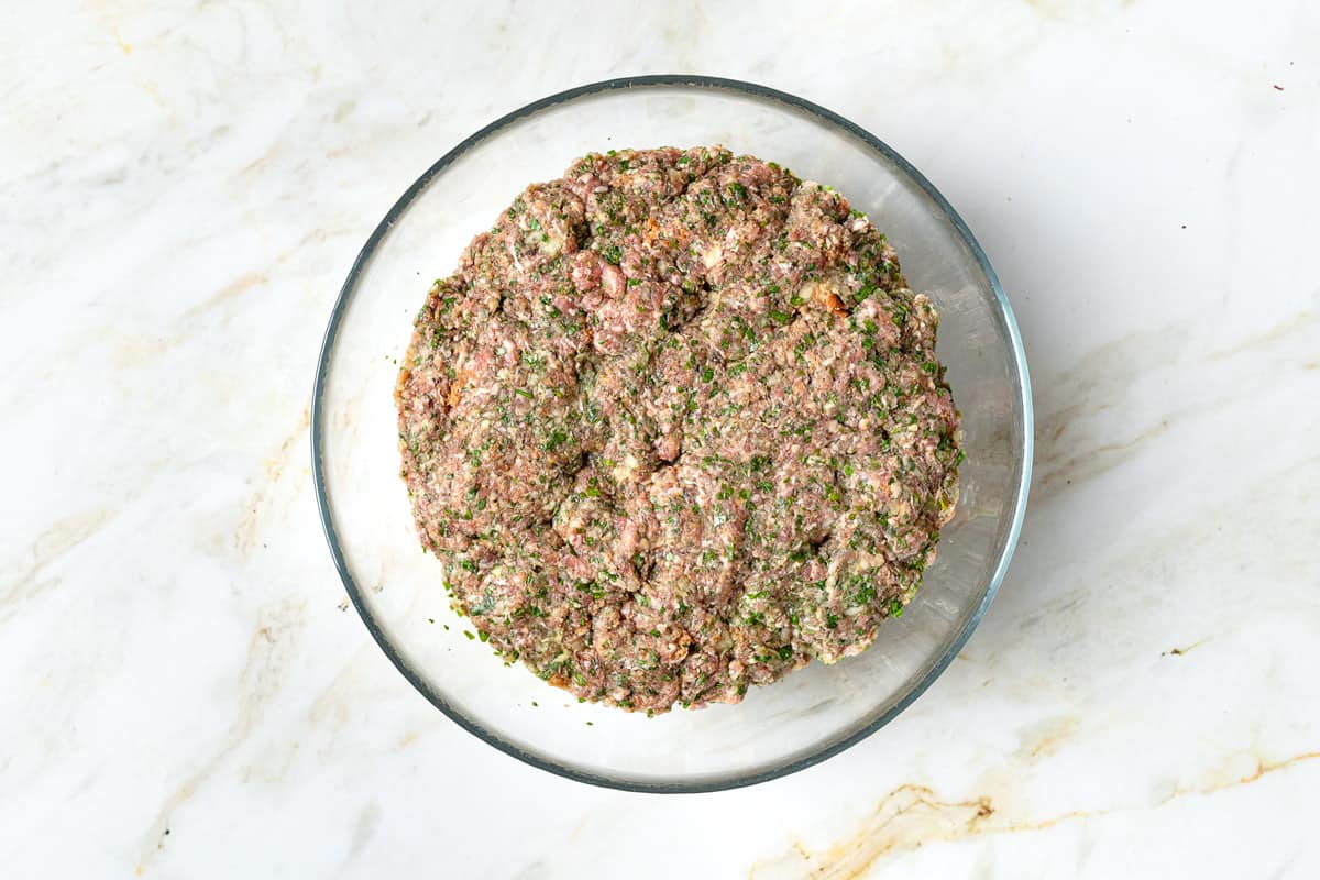 meatball mixture in a clear mixing bowl.