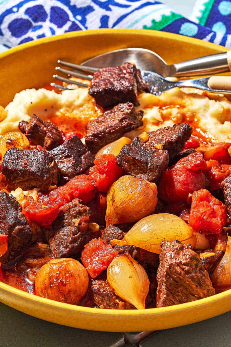 Close up shot of greek beef stew showing the soft pearl onions and seared beef.