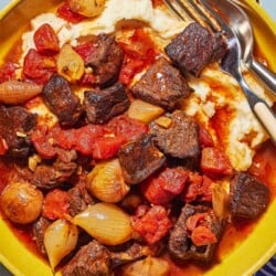 overhead shot of greek beef stew on top of mashed potatoes.