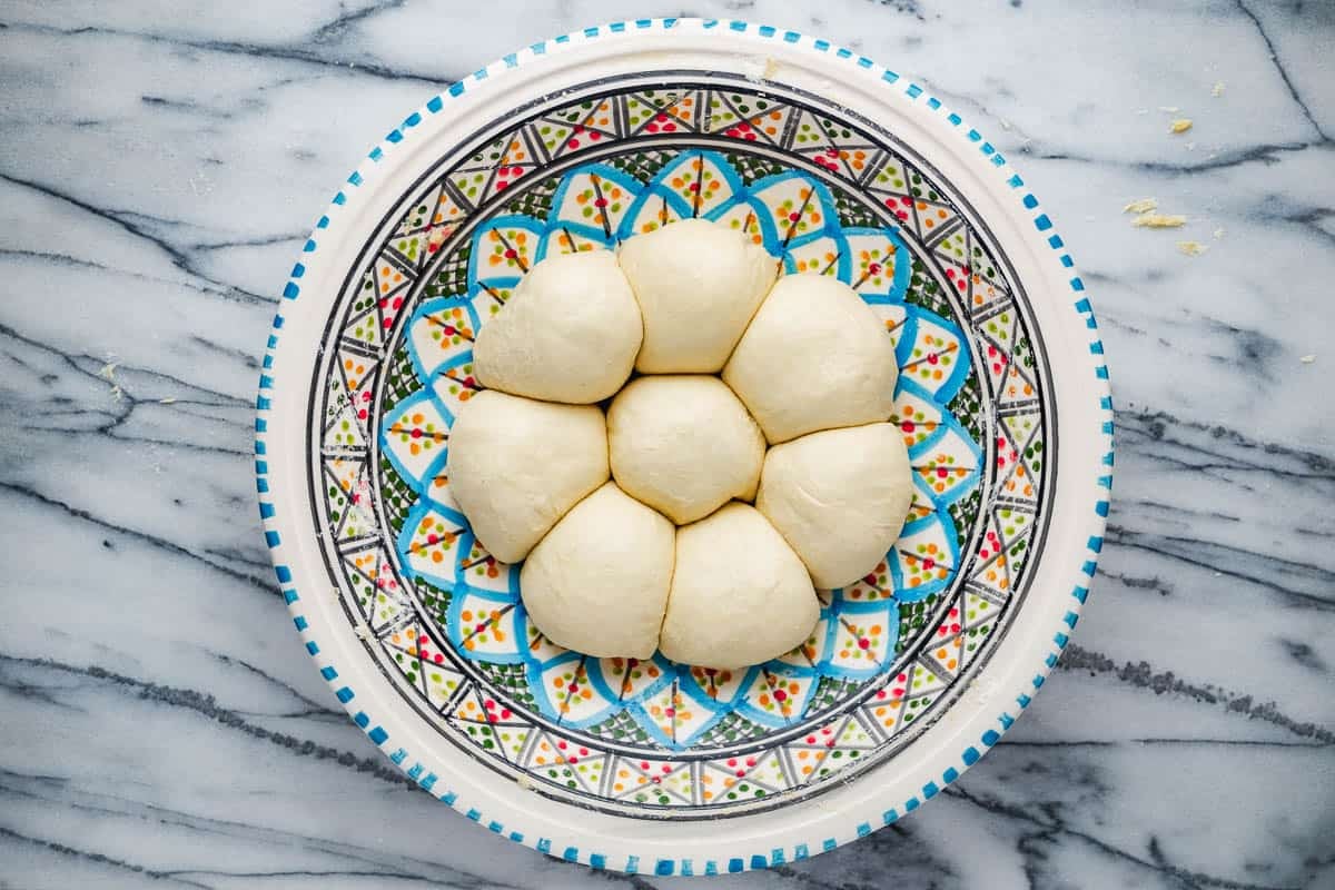 eight small mlewi dough balls in a bowl.