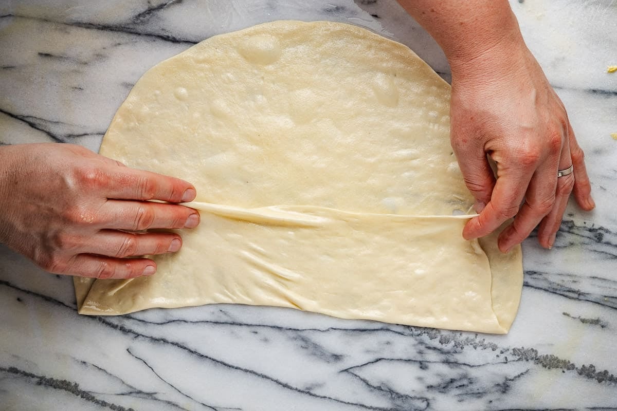 stretched mlewi flatbread dough being folded.