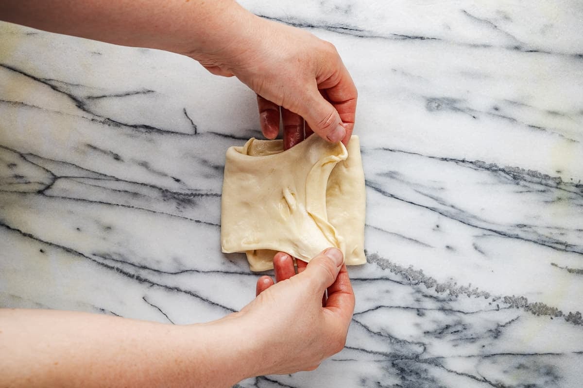 stretched mlewi flatbread dough being folded.