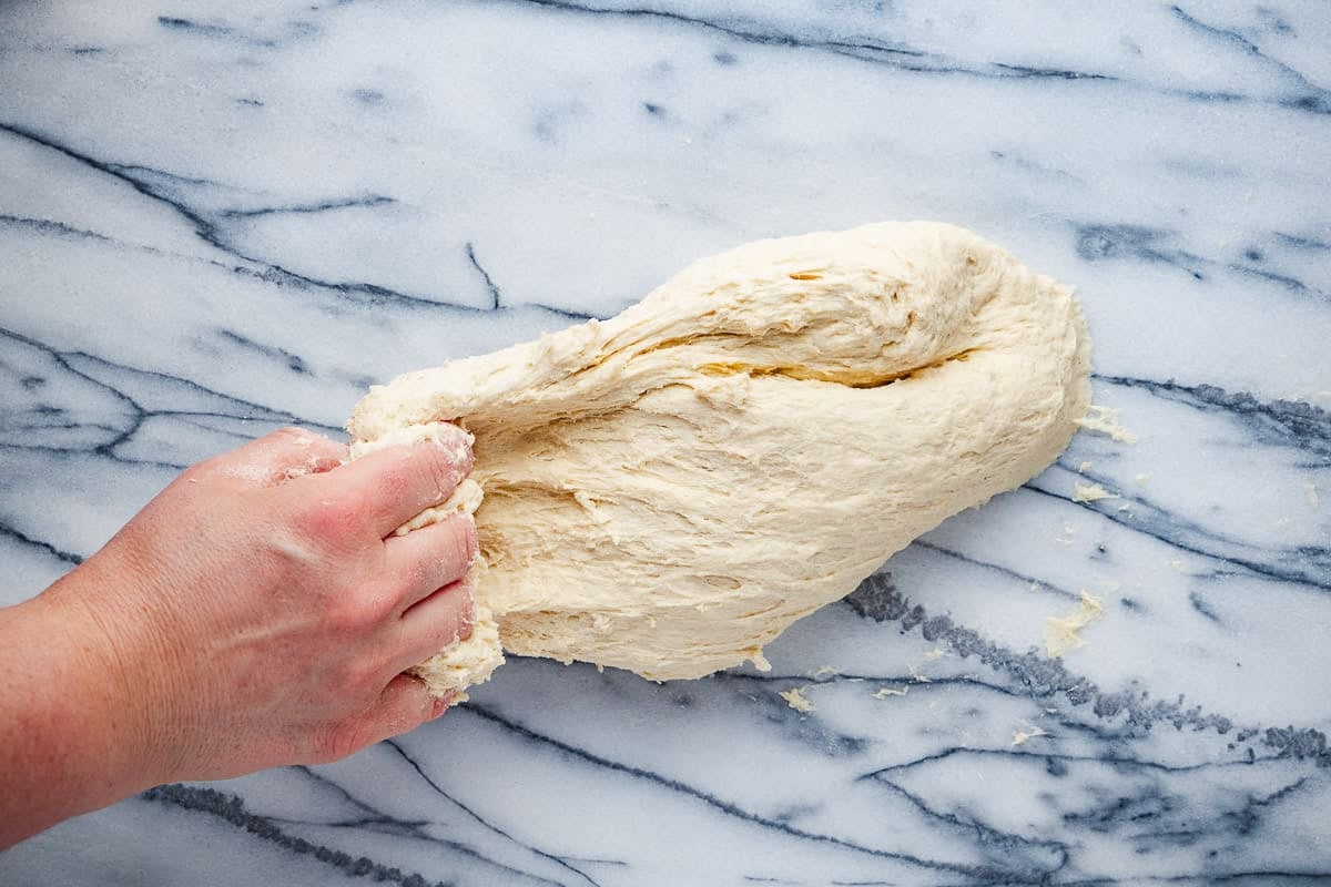 mlewi flatbread dough starting to be stretched.