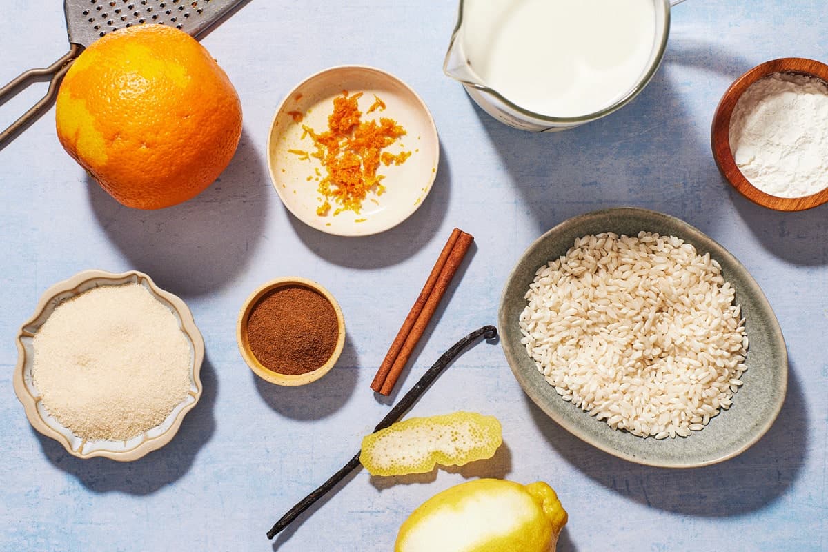 Ingredients for Rizogalo, including cinnamon, vanilla, rice, cornstarch, sugar, orange zest, and milk.